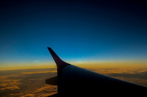 The wing of a plane flying across the globe